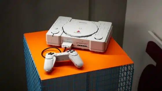 Official LEGO PlayStation 72306 display model and brick-built controller on an orange table