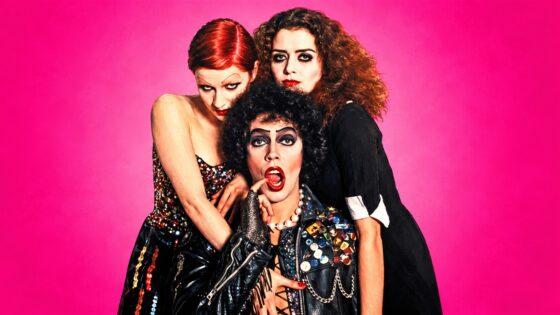 AI-stylised Rocky Horror trio portrait: Frank-N-Furter in front, Columbia and Magenta behind, with theatrical makeup and costumes against a hot-pink backdrop.