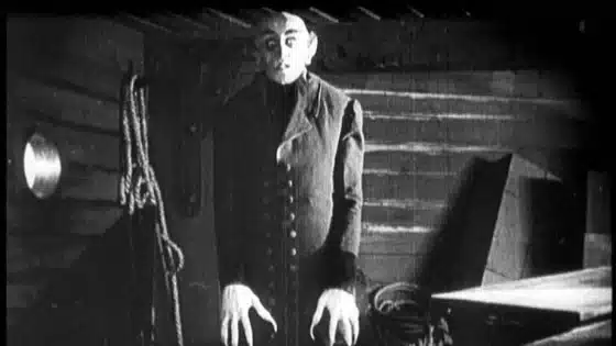 Max Schreck as Count Orlok inside a ship in Nosferatu (1922), in a black-and-white film frame